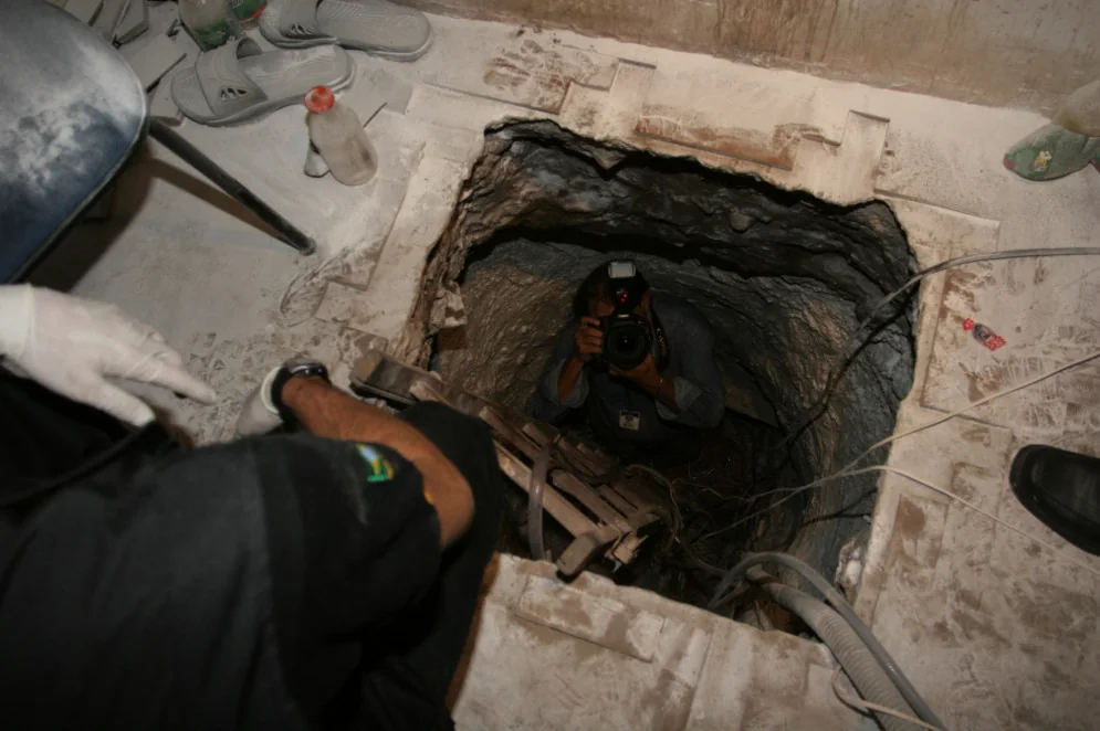 Investigators and journalists examine the tunnel entrance